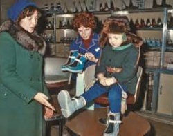 Примеряют сапожки мальчику в магазине эпохи СССР.